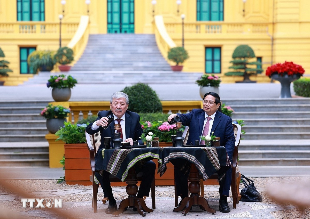 Thủ tướng Phạm Minh Chính và Thủ tướng Kyrgyzstan Adylbek Kasymaliev cùng thưởng thức văn hóa cà phê Việt Nam trong khuôn viên Di tích Phủ Chủ tịch. (Ảnh: Dương Giang/TTXVN)