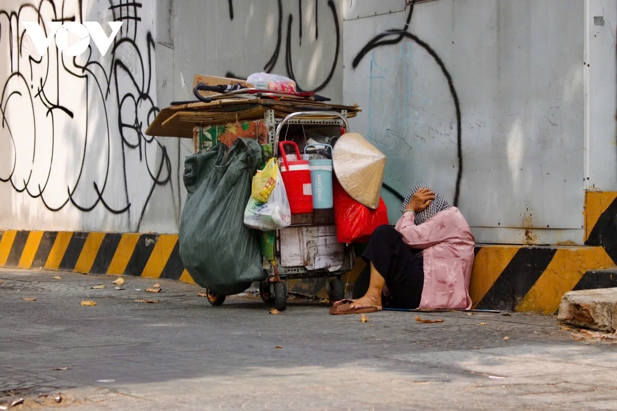 On tree-lined sidewalks, workers take brief naps under the scorching sun, regaining energy before resuming work.
