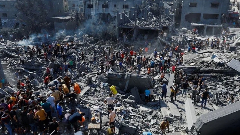 Những người Palestine đang tìm kiếm người thương vong tại khu vực bị Israel tấn công ở phía Nam Dải Gaza. Ảnh: Reuters