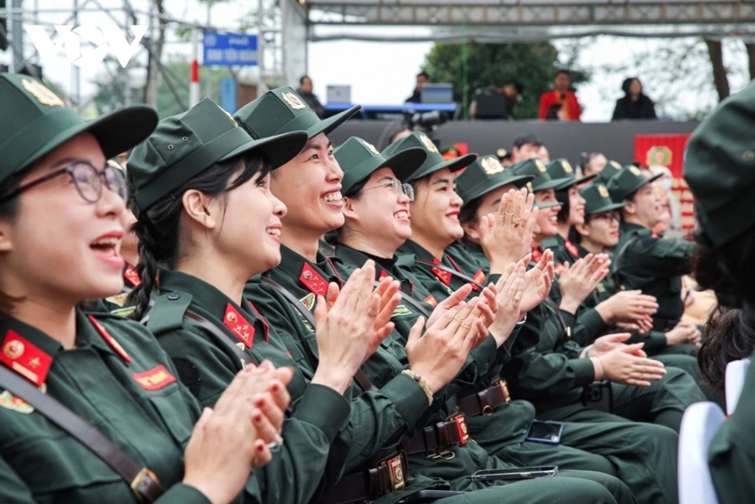 Female officers on the stage receive encouragement from their comrades.