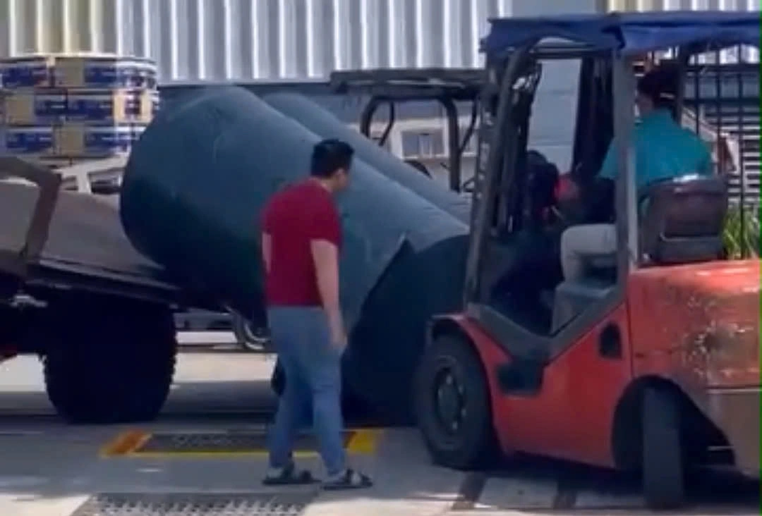 Mọi người cố gắng kéo 3 cuộn vải ra bên ngoài để cứu nam bảo vệ (ảnh cắt từ video)