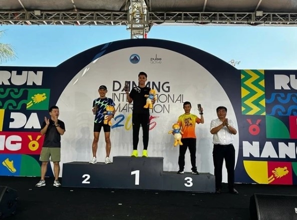 Huynh Anh Khoi (centre) takes the award for the men’s 42km division in the Da Nang International Marathon 2025. (Photo courtesy of Da Nang International Marathon 2025)