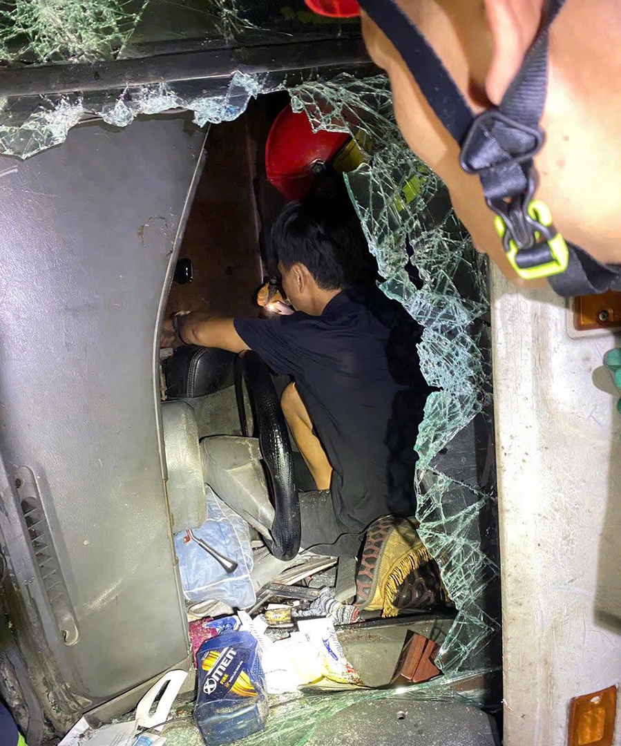 Lực lượng chức năng vào ca bin để hỗ trợ đưa lái xe ra ngoài (Ảnh: Cảnh sát PCCC)