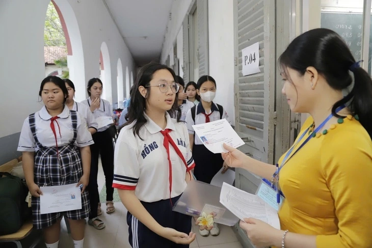 Cán bộ coi thi gọi thí sinh vào phòng thi tại điểm thi học sinh giỏi lớp 9 Trường THPT Marie Curie - Ảnh: NHƯ HÙNG