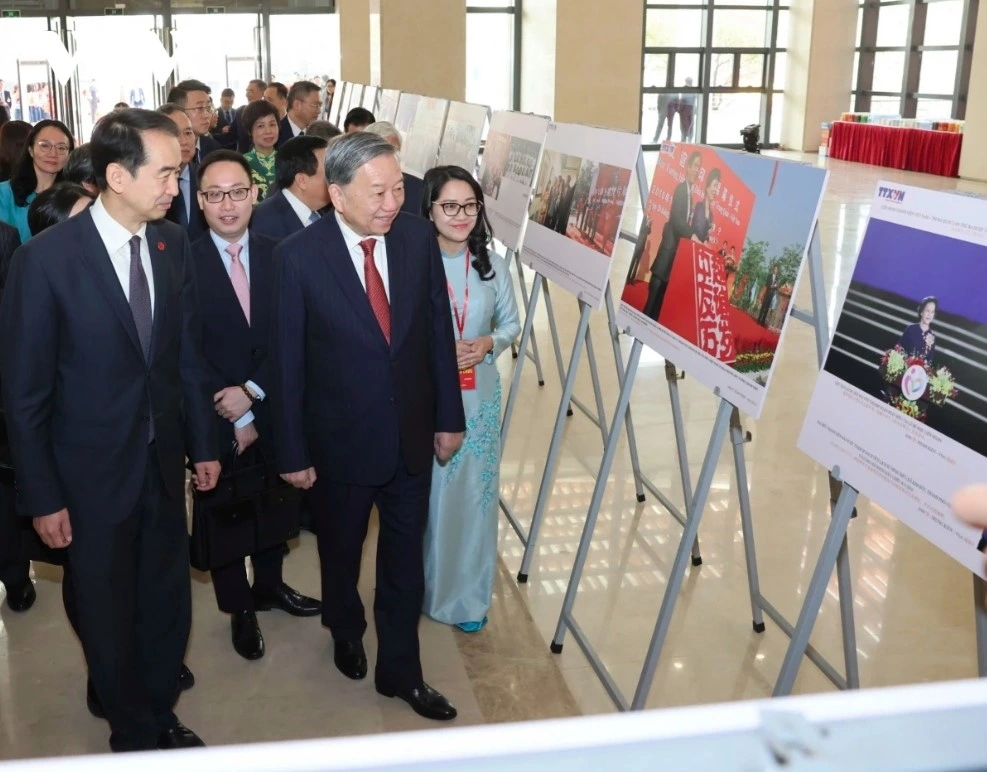 Party chief and delegates pay a visit to a photo exhibition showcasing milestones in Vietnam-China relationship over the past 75 years.