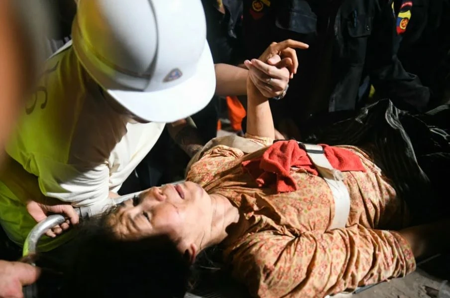 Người phụ nữ được đưa ra khỏi đống đốt nát trong trận động đất ở Myanmar. Ảnh: AFP