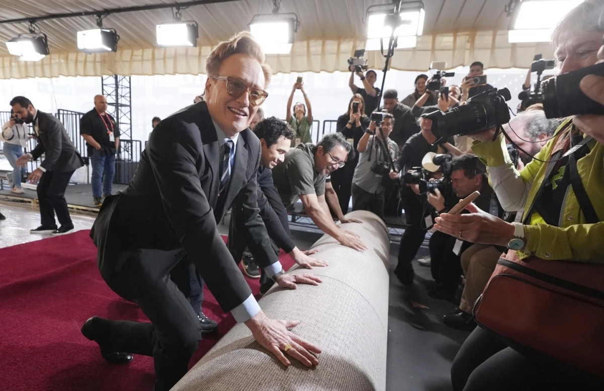 Danh hài Conan O'Brien, người đảm nhận vai trò dẫn dắt lễ trao giải năm nay giúp trải thảm đỏ tại Nhà hát Dolby hôm 26/2. Ảnh: AP