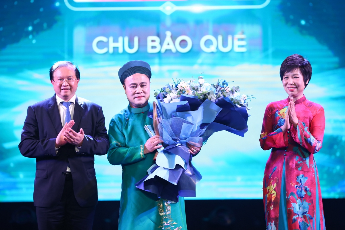 Lễ trao giải năm nay còn có một phần đặc biệt, là hạng mục Nghệ sĩ truyền cảm hứng – nơi những cá nhân không chỉ ghi dấu ấn bằng thành tựu nghệ thuật mà còn truyền tải những thông điệp nhân văn, khích lệ tinh thần và đánh thức niềm đam mê trong từng trái tim. Tổng Giám đốc TTXVN Vũ Việt Trang (phải) và Thứ trưởng Bộ Văn hóa Thể thao và Du lịch Tạ Quang Đông (trái) trao Giải Nghệ sĩ truyền cảm hứng cho GS-TS - Nghệ sĩ Chu Bảo Quế.