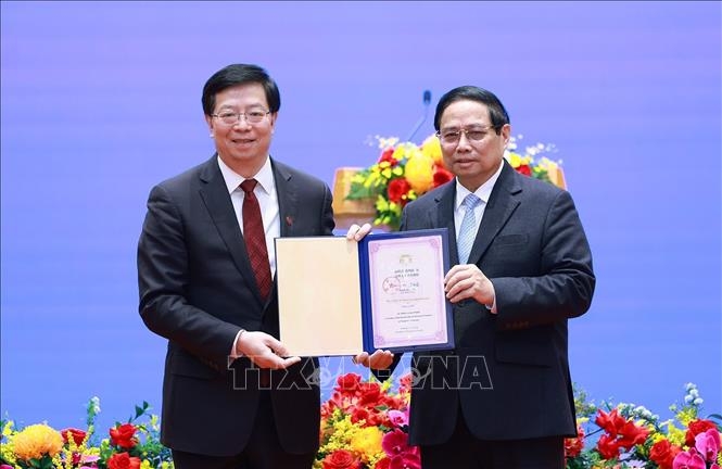 Giáo sư, Tiến sĩ, Viện sĩ Khưu Dũng trao tặng Thủ tướng Phạm Minh Chính danh hiệu "Giáo sư danh dự Đại học Thanh Hoa".  (Ảnh: TTXVN)