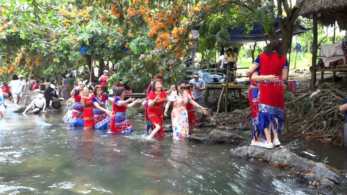 Người dân và du khách tham quan bên suối Tà Má.