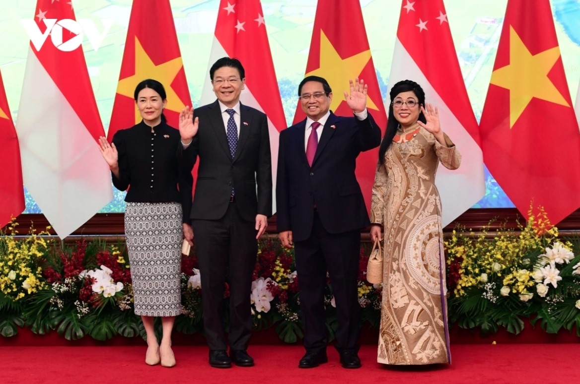 The two PMs and their spouses pose for a group photo.