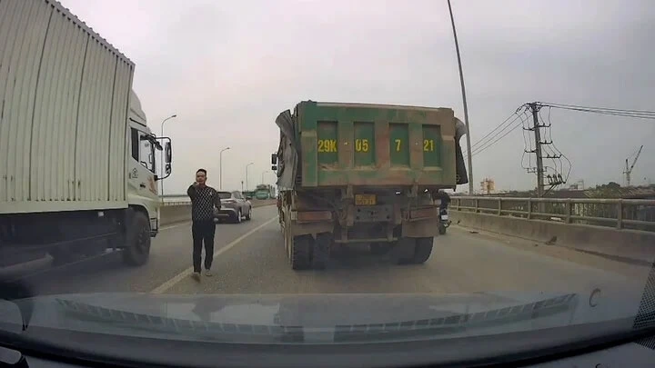 Tài xế xe tải dừng xe trên cầu và đi về phía ô tô con