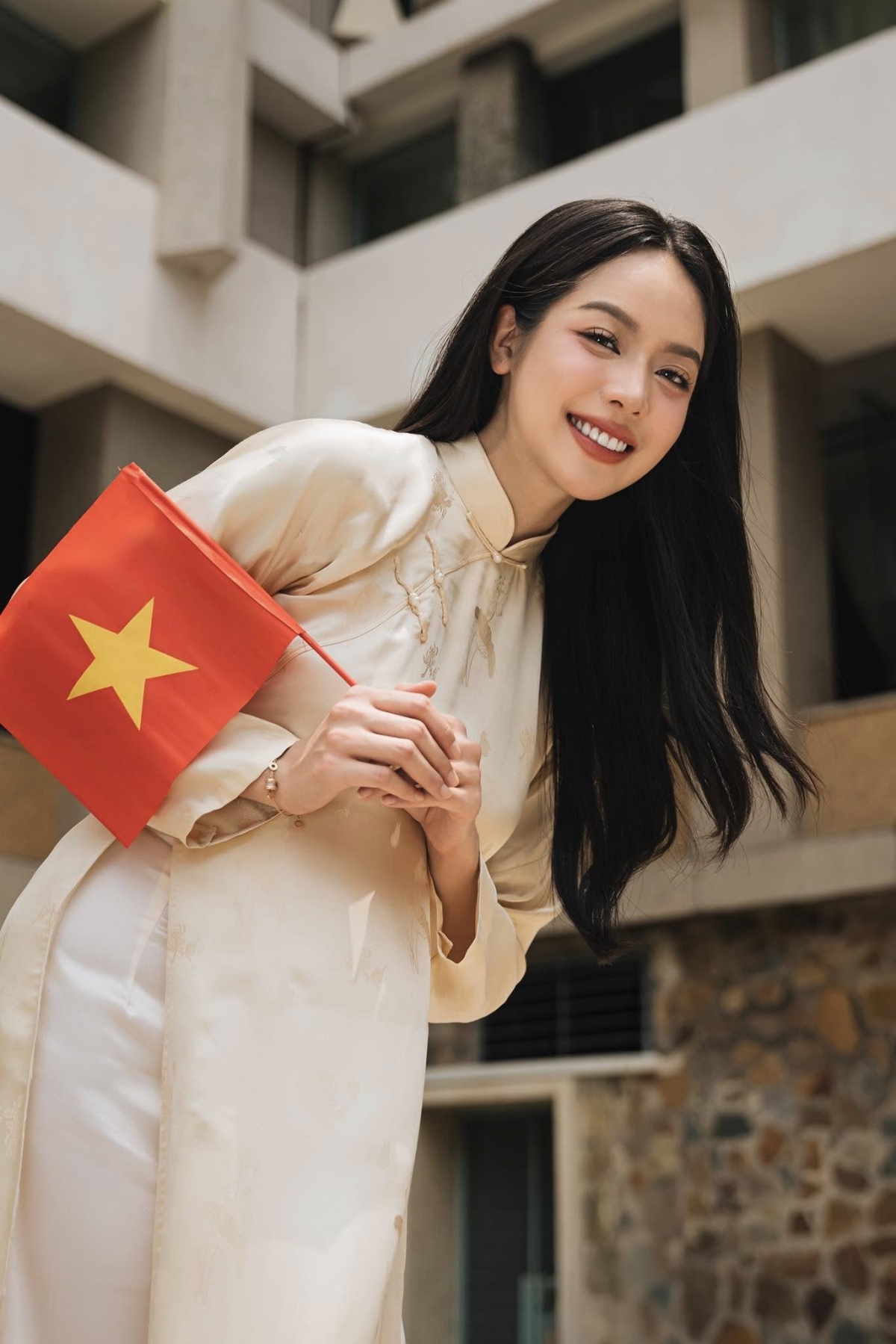 Hoa hậu Thanh Thủy diện áo dài, cầm cờ đỏ sao vàng nhân dịp kỷ niệm 50 năm Ngày Giải phóng miền Nam, thống nhất đất nước. (Nguồn: FBNV)