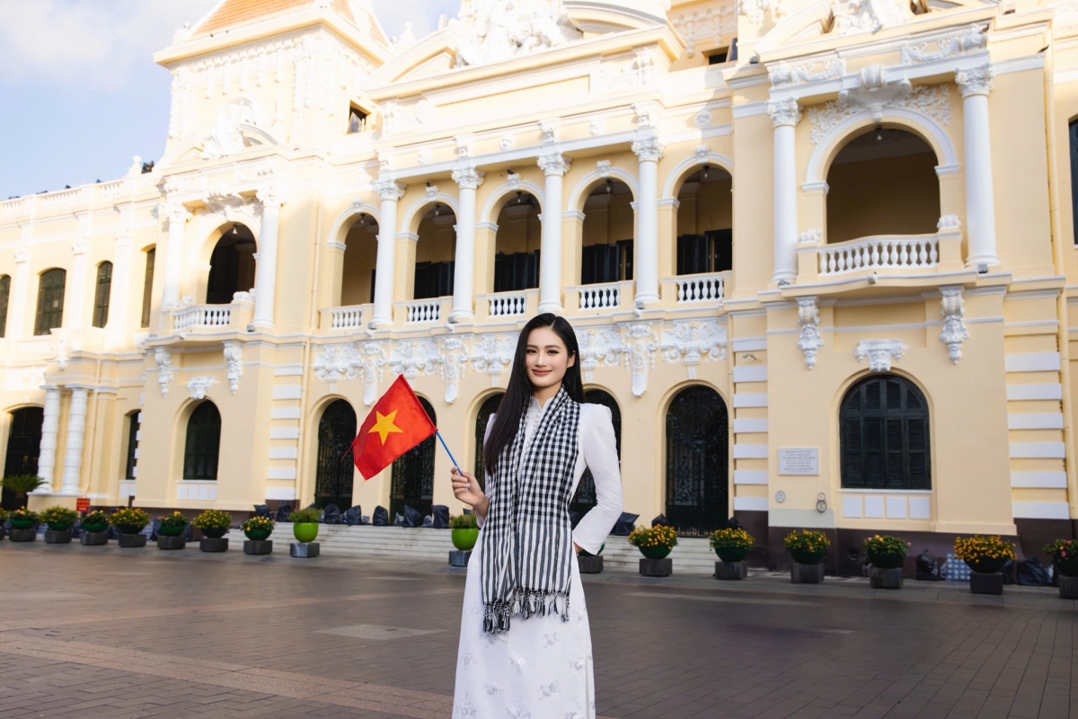 Hoa hậu Ý Nhi ghi lại nhiều khoảnh khắc với áo dài trắng và khăn rằn tại UBND Thành phố Hồ Chí Minh. "Áo dài trong gió, cờ bay trên trời. Một dải non sông, vẹn nguyên rạng ngời", nàng hậu viết.
