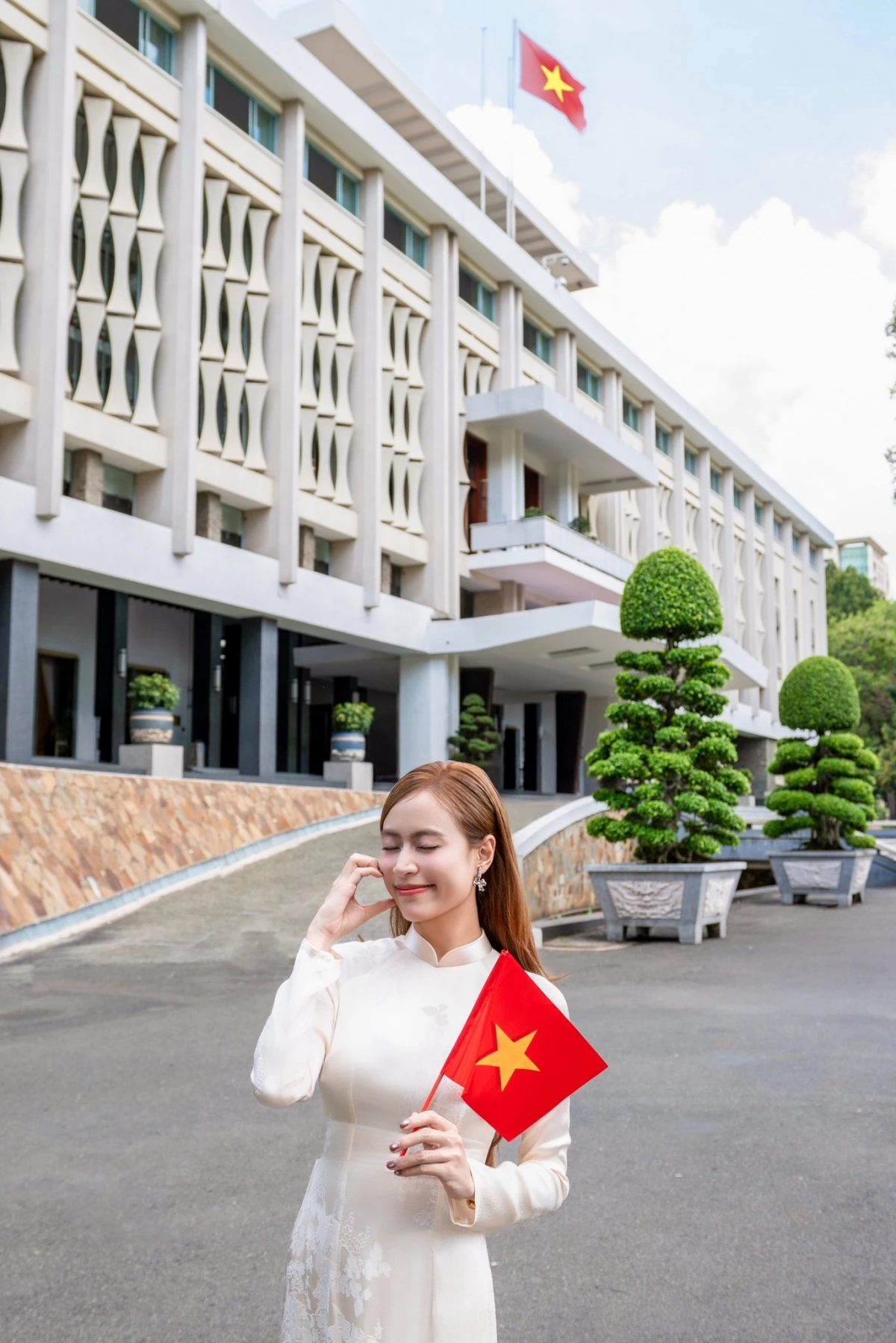 Hoàng Thùy Linh mặc áo dài trắng thướt tha, cầm lá cờ Việt Nam, đứng trước tòa nhà Dinh Độc Lập. "Chúng ta là người Việt Nam", cô tự hào bày tỏ.