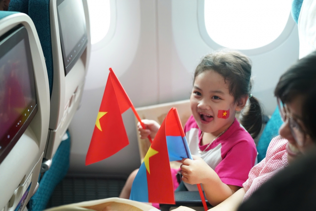 Các hành khách cầm lá cờ đỏ Sao vàng và cờ mặt trận Mặt trận Dân tộc giải phóng Miền Nam Việt Nam - biểu tượng thiêng liêng của hòa bình, độc lập.