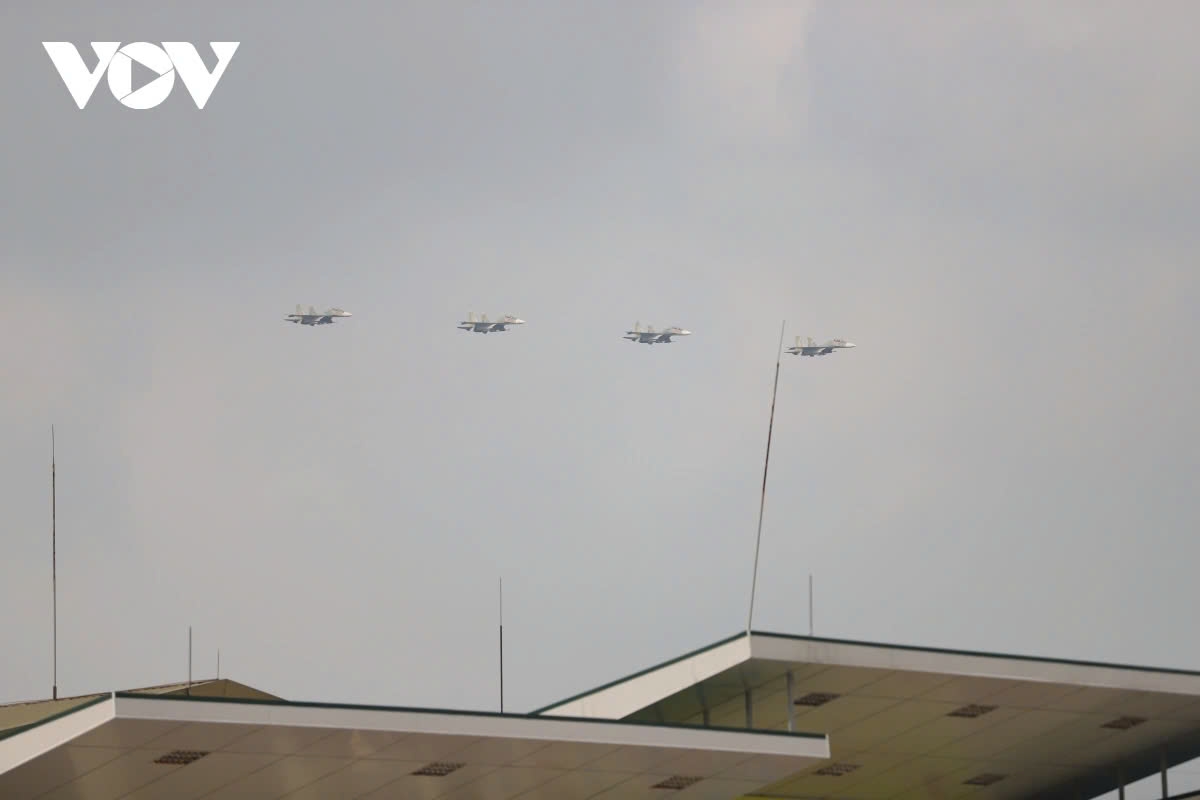 Following them are fighter jet formations including Su-30MK2 and Yak-130 aircraft performing welcome passes and aerobatic maneuvers in the sky.