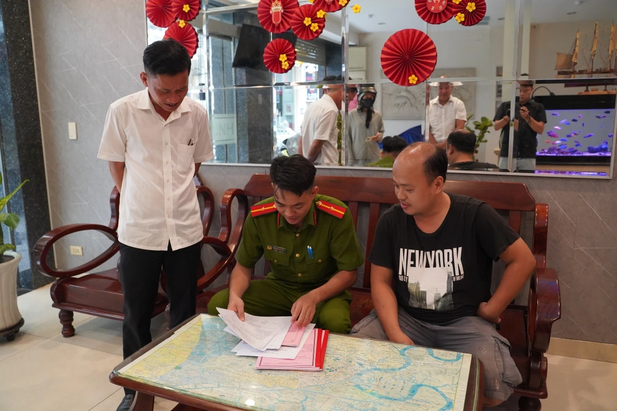 Công an làm việc với chủ trọ trong khi kiểm tra.
