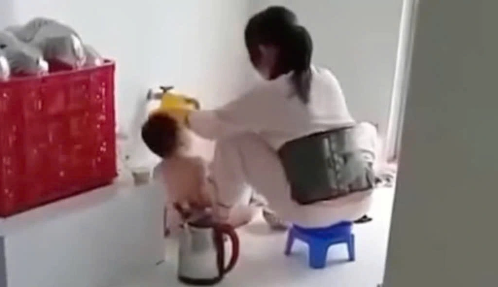 Bảo mẫu " cưỡng ép" trẻ ăn gây bức xúc trên cộng đồng mạng (ảnh cắt từ clip)