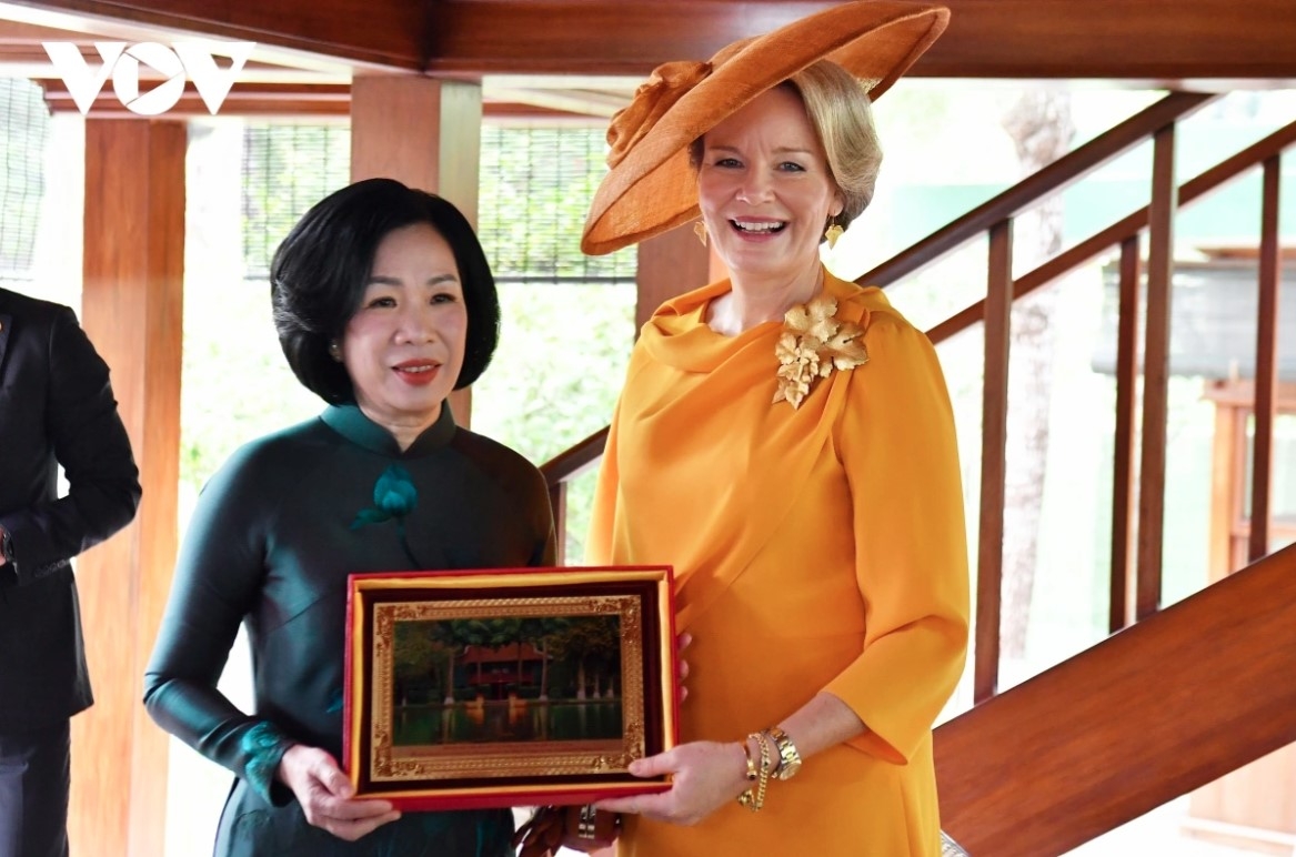 Vietnamese President's spouse Nguyen Thi Minh Nguyet presents a photo of President Ho Chi Minh’s stilt house to Queen Mathilde of Belgium.