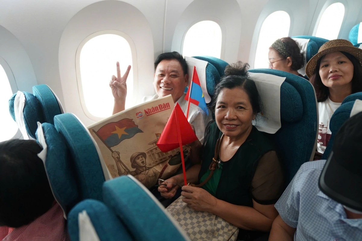 Niềm vui rạng rỡ trên gương mặt hành khách khi được cầm trên tay lá cờ Tổ quốc và ấn phẩm đặc biệt báo Nhân Dân trong chuyến bay ý nghĩa ngày 30/4.