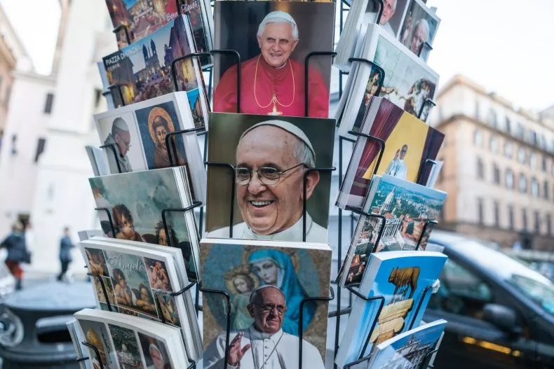 Bưu thiếp và quà lưu niệm mang hình Giáo hoàng Francis và Giáo hoàng Benedict XVI được bày tại trung tâm Rome, năm 2014. Ảnh: Getty