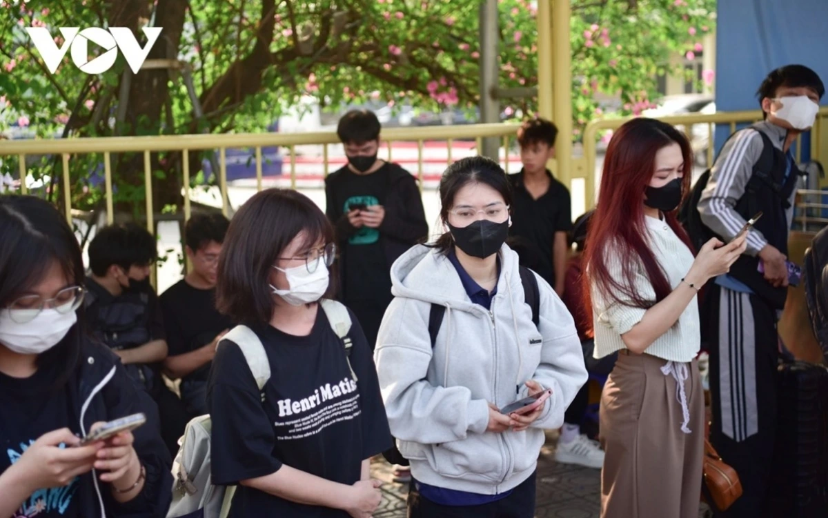 People queue at Giap Bat bus station while waiting for their bus.