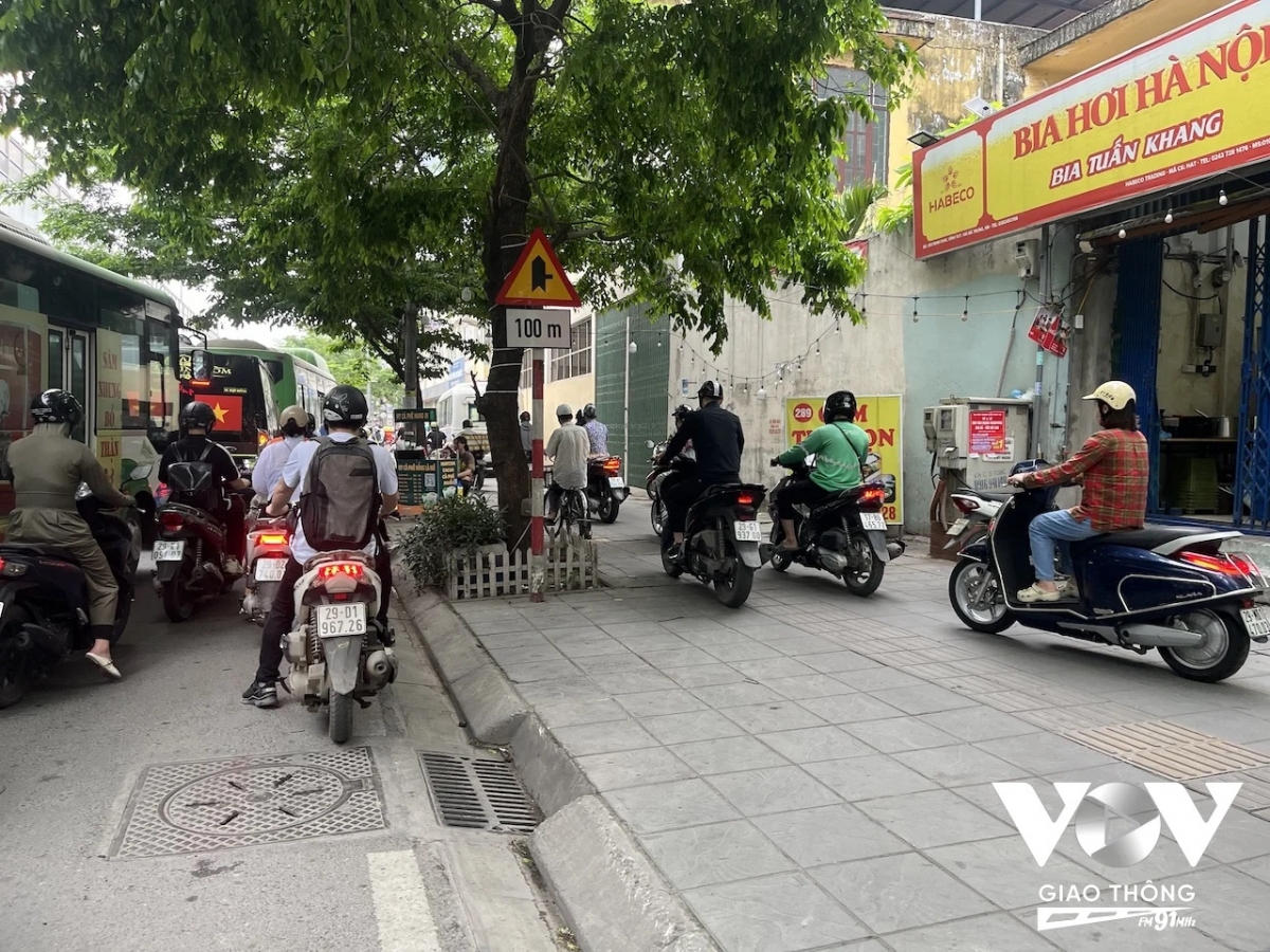 Giờ cao điểm sáng, rất nhiều người điều khiển xe máy leo lên vỉa hè trên phố Minh Khai...
