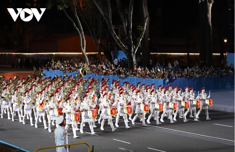 The military band, with a formation of female drummers marches pass the grandstand