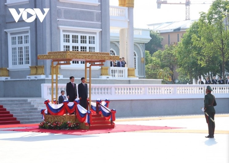 The two leaders stand on the podium while military bands play the national anthems of both nations.