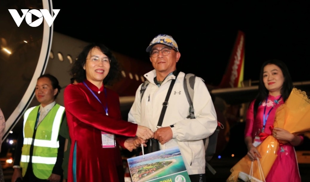 Representatives of the Quang Binh Department of Culture, Sports and Tourism present gifts to passengers on the flight.