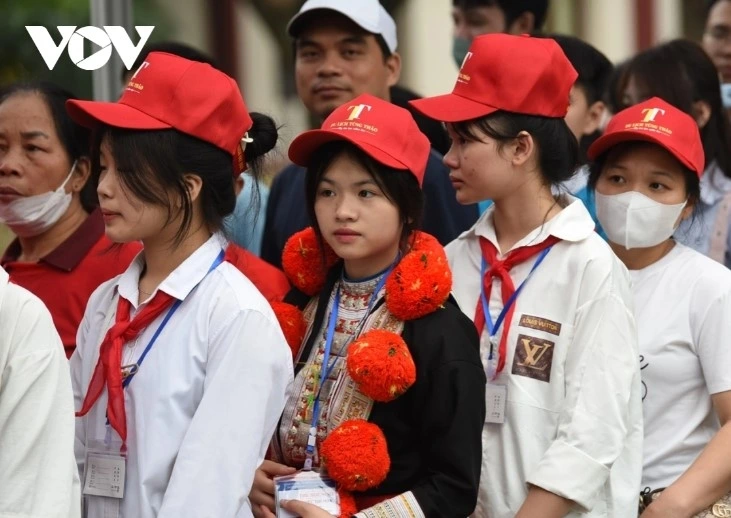 Ethnic students in traditional costumes line up to pay their respects to President Ho Chi Minh.