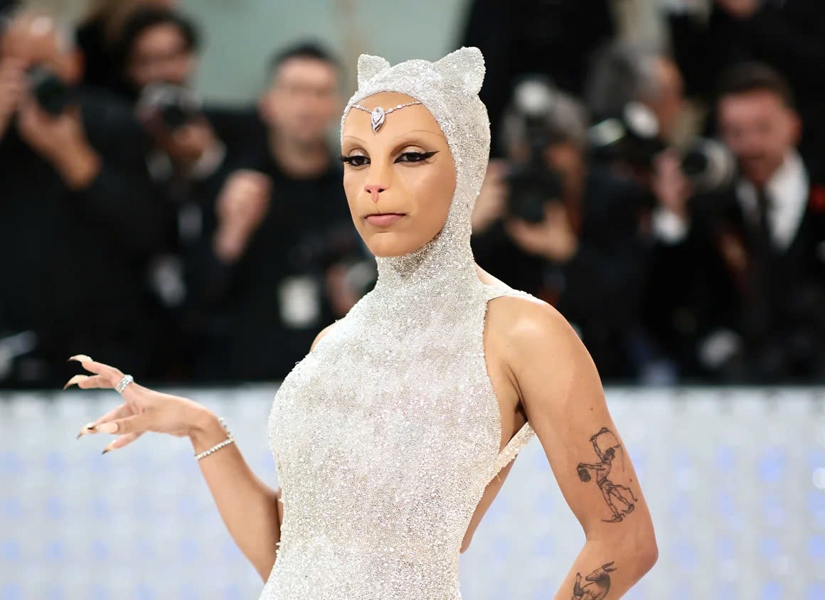 Doja Cat gây chú ý tại Met Gala 2023 khi xuất hiện với gương mặt giả mô phỏng chú mèo cưng của cố Karl Lagerfeld, tạo nên khoảnh khắc thời trang độc đáo.