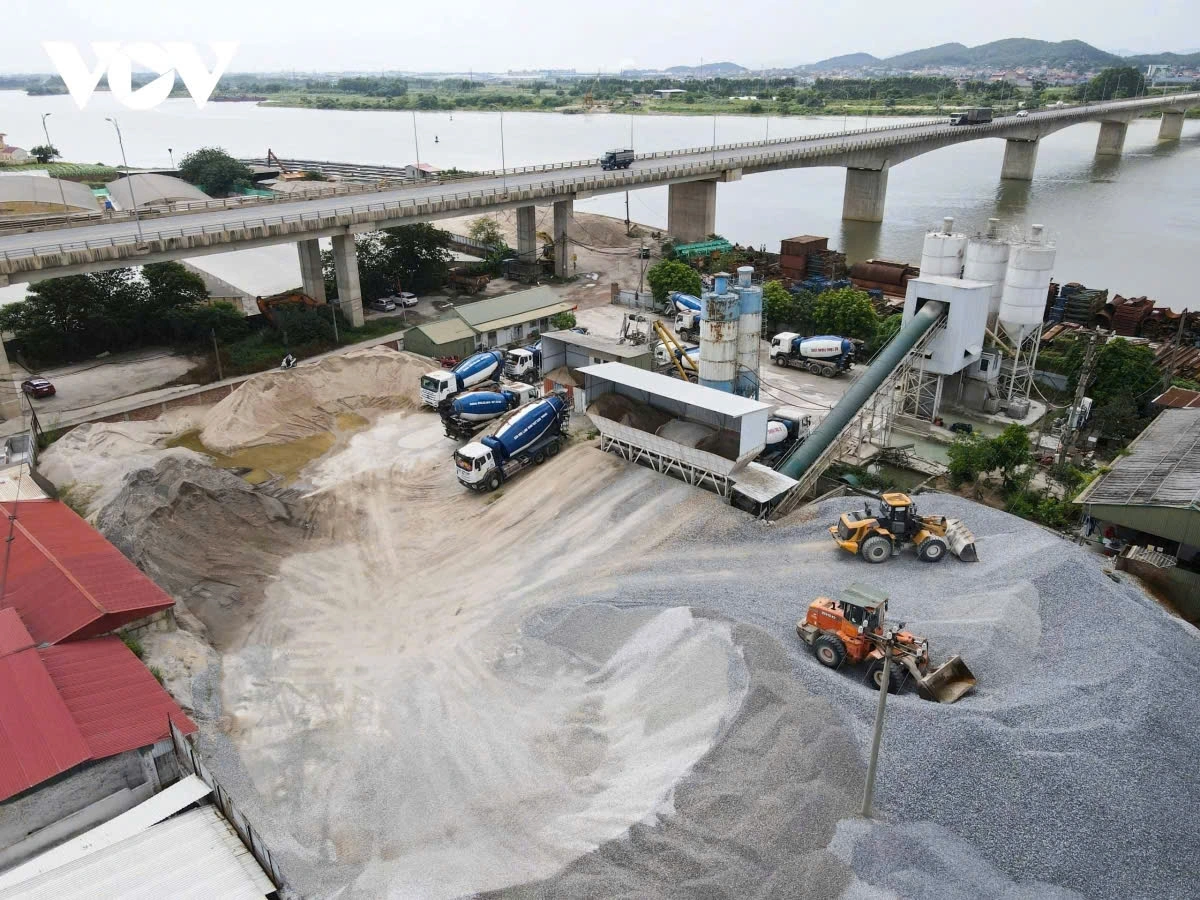 Trạm trộn bê tông, bãi tập kết vật liệu xây dựng hoạt động tại chân cầu Bình Than gây cản trở hành lang thoát lũ 