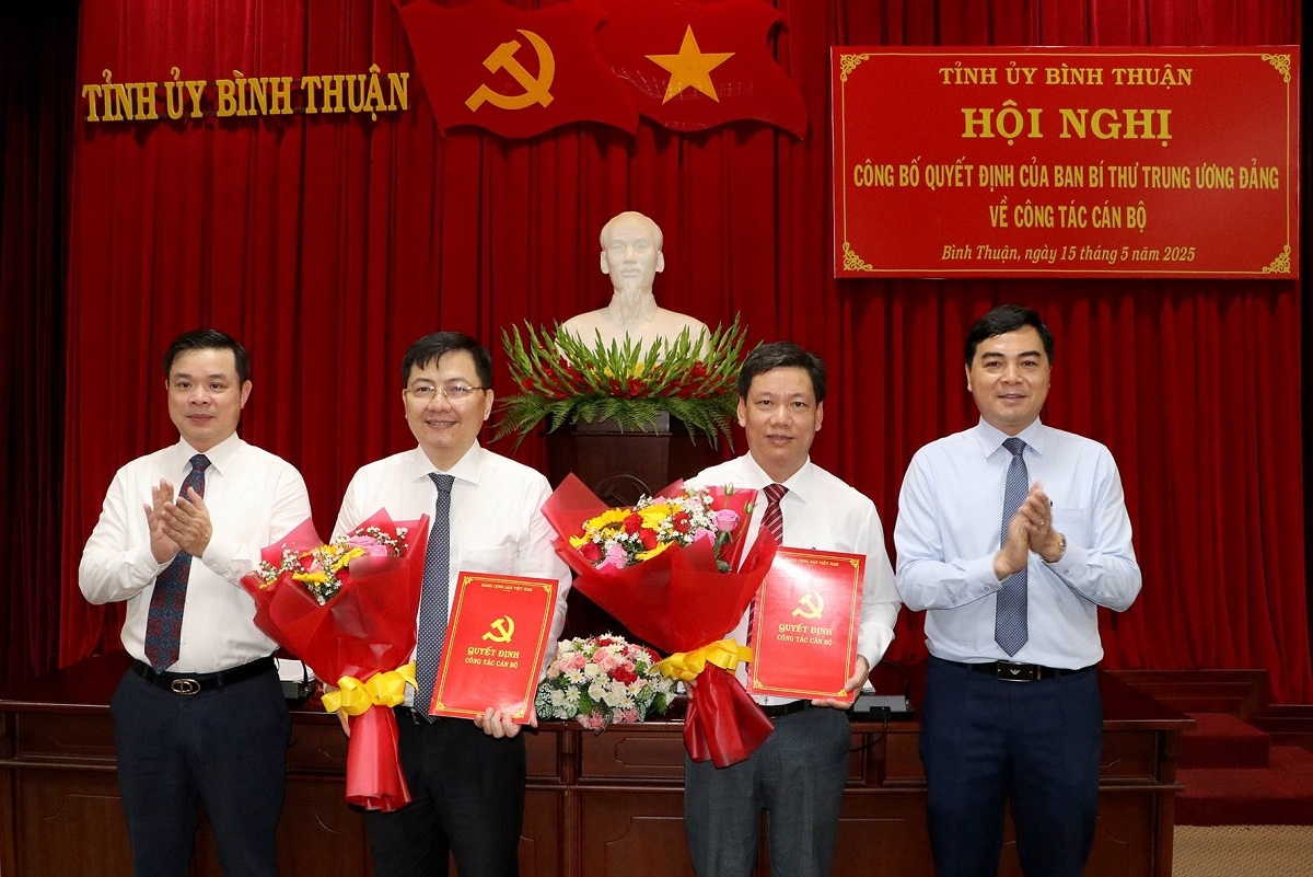 Ông Đỗ Văn Chung (thứ 2 từ phải sang) và ông Phan Thế Hanh nhận quyết định và hoa chúc mừng. Ảnh: T.D