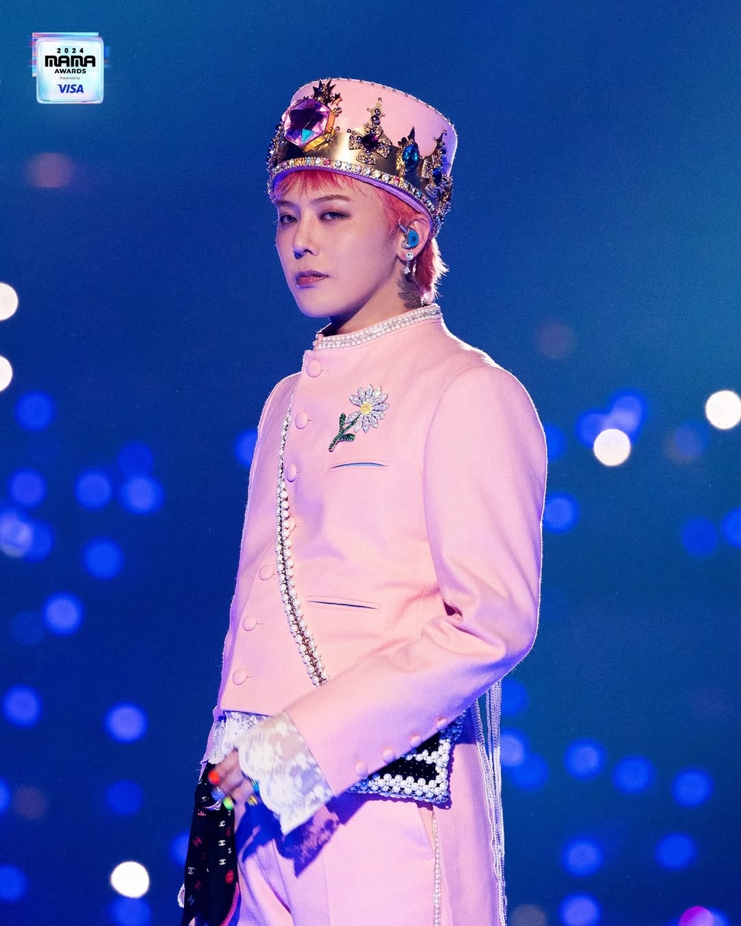 G-Dragon sở hữu một chiếc trâm cài áo hình hoa cúc với cánh hoa rủ xuống, một sự hợp tác giữa thương hiệu Peaceminusone của G-Dragon và hãng đồng hồ xa xỉ Jacob &amp; Co. Phụ kiện độc đáo này được làm bằng vàng trắng 18K, có 9,31 carat kim cương trắng, 1,94 carat đá sapphire vàng và 4,2 carat charoite. Phụ kiện này có giá khoảng 112.500 USD (2,9 tỷ đồng).