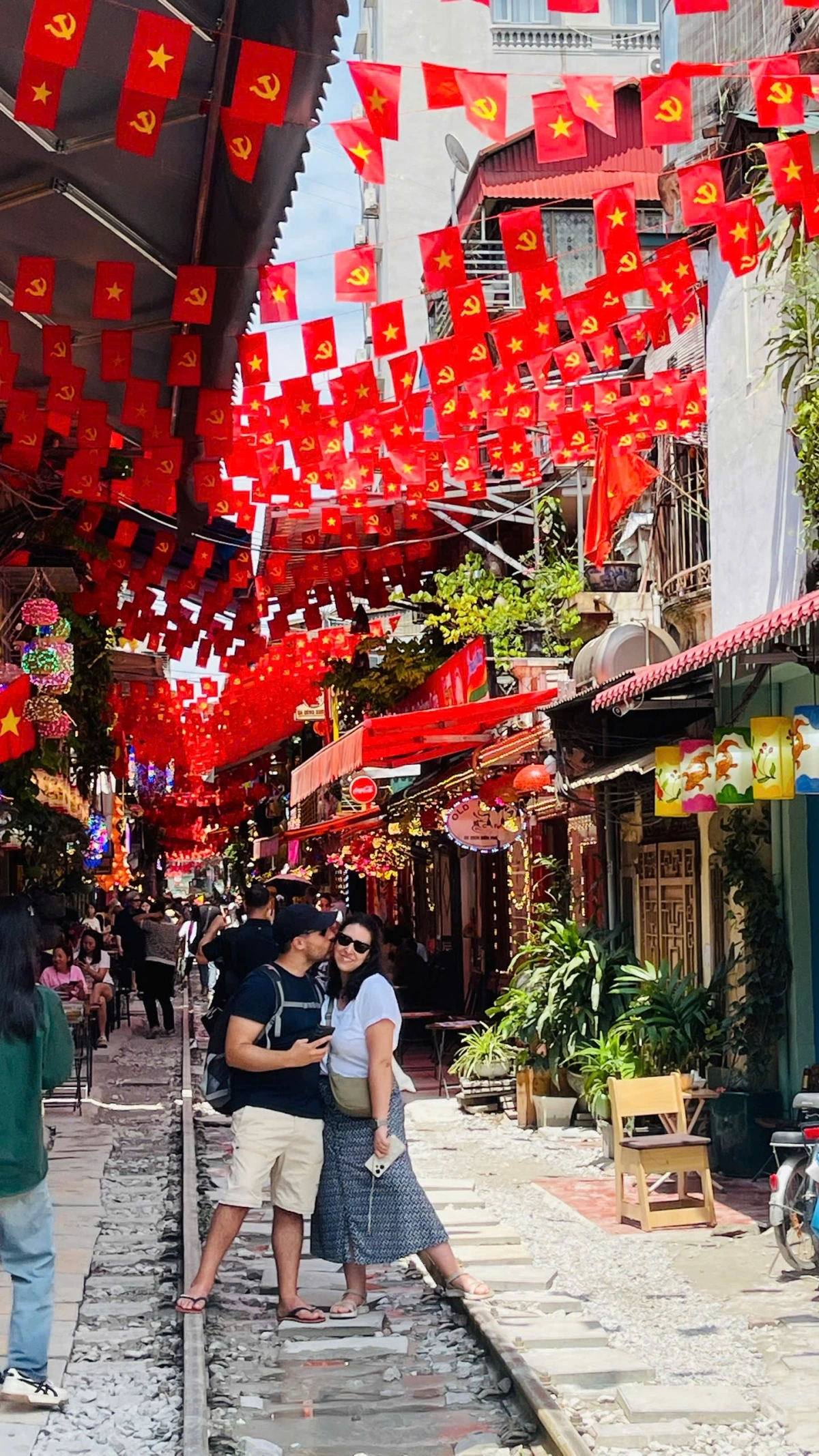 Quán cafe đường tàu ở phố Khâm Thiên, Điện Biên Phủ, Phùng Hưng... rực sắc cờ đỏ sao vàng thu hút nhiều du khách nước ngoài đến check in.