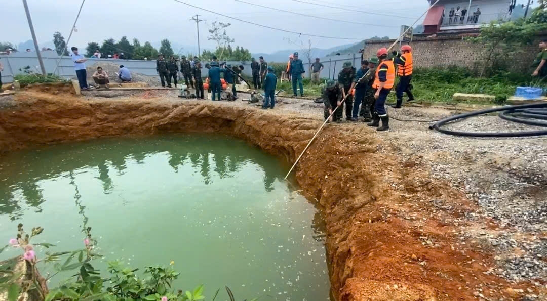 Dùng sào dài, gắn góc sắt để tìm kiếm dưới hố sâu nhưng không có kết quả