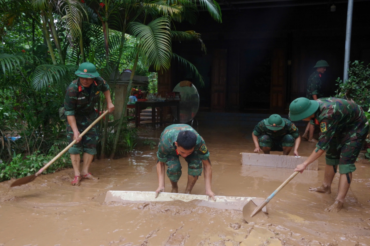 Lực lượng quân đội giúp dân dọn bùn đất sau khi nước rút.