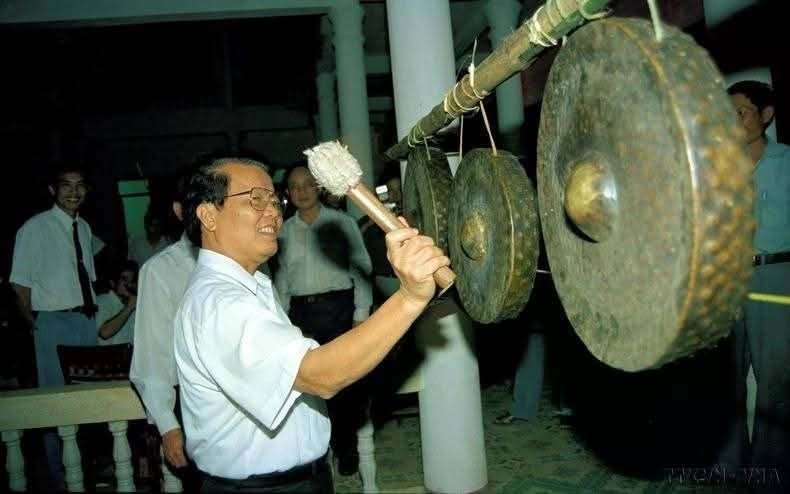 Chủ tịch nước Trần Đức Lương gõ chiêng Tây Nguyên khi giao lưu với đồng bào. (Ảnh: Thông tấn xã Việt Nam)