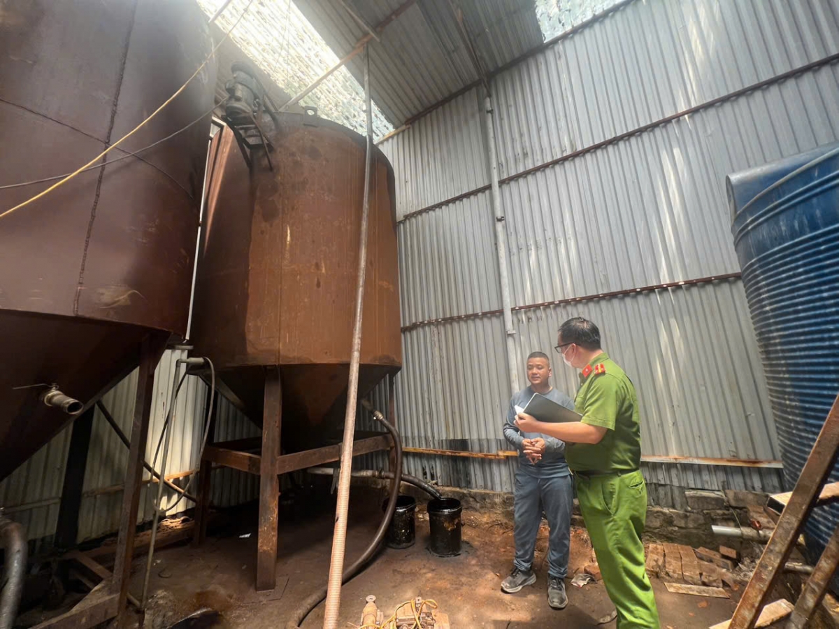 Bùi Quốc Giang (áo xanh sáng màu) làm việc với cơ quan công an.