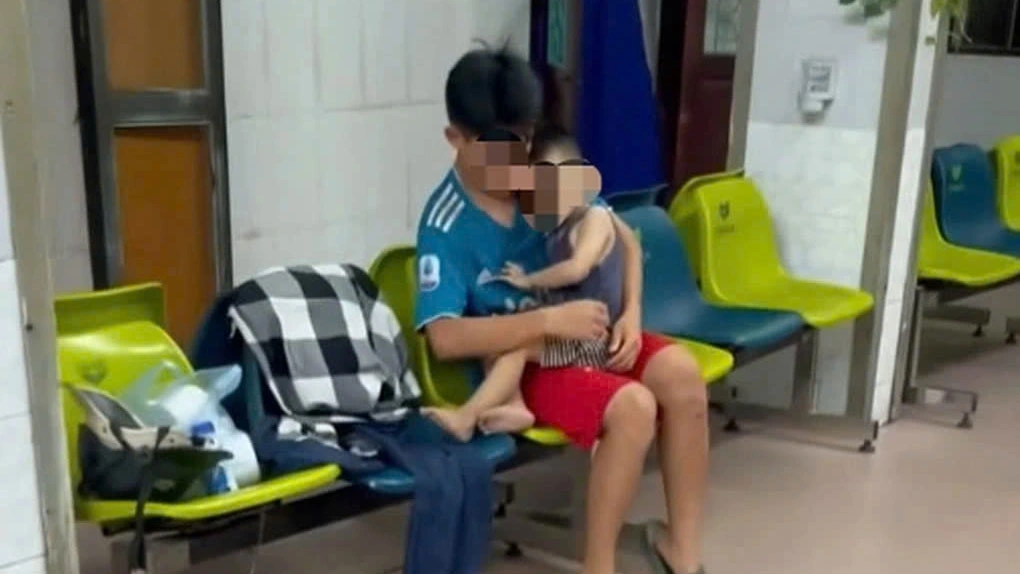 Cháu bé ở ngoài hành lang đợi cấp cứu tại bệnh viện. Ảnh: Cắt từ clip