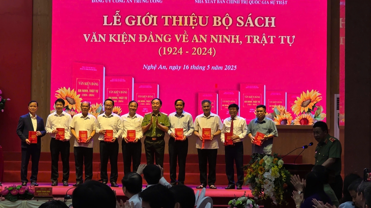 Thứ trưởng Bộ Công an Trần Quốc Tỏ tặng sách cho các đại biểu tham dự hội thảo. 