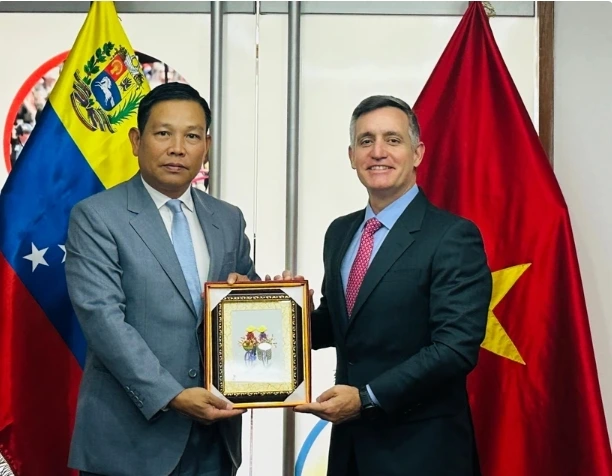 Vietnamese Ambassador to Venezuela Vu Trung My gives a present to Venezuelan Sports Minister Franklin Cardillo. (Photo: The courtesy of the embassy)