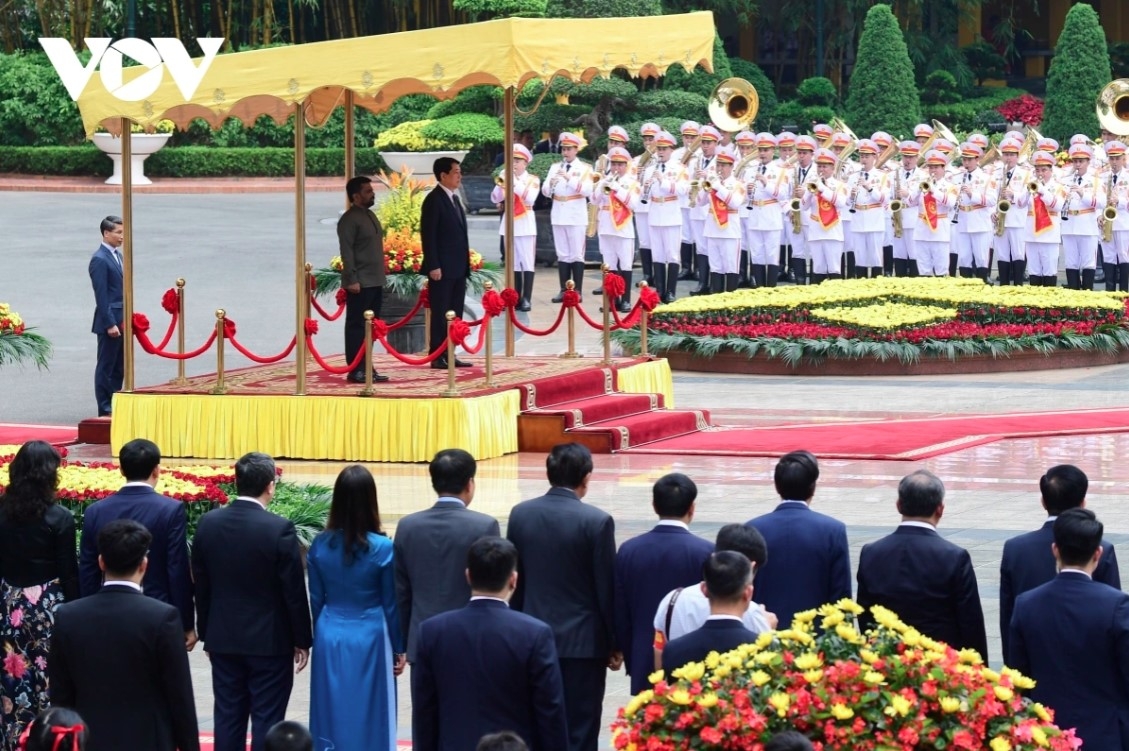 The two Presidents stand on the podium while military bands play the national anthems of both countries.