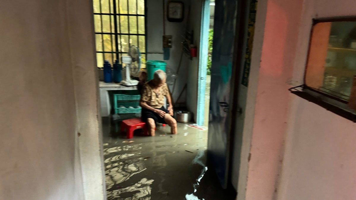 Mưa ngập ở TP.Dĩ An, một cụ già ngồi chờ người đến hỗ trợ 