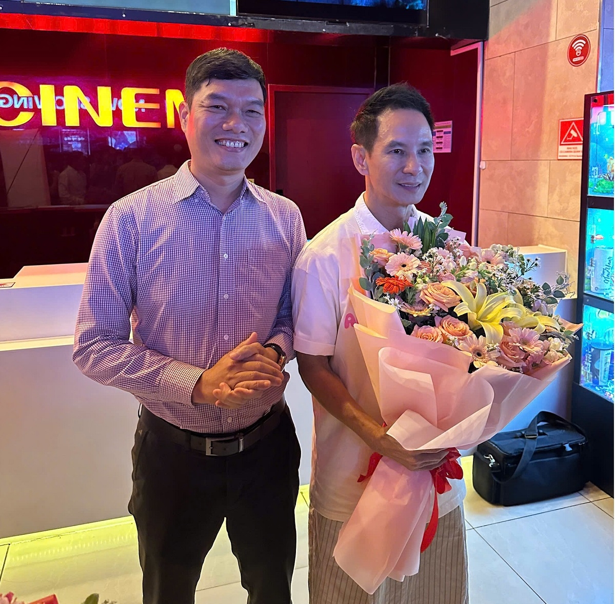 Phó Giám đốc Sở Văn hoá, Thể thao và Du lịch tỉnh Bình Thuận Nguyễn Lê Thành và đạo diễn Lý Hải (cầm hoa). Ảnh: SVH