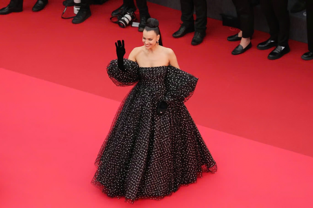 Irina Shayk tiếp tục chứng minh đẳng cấp thời trang khi xuất hiện lộng lẫy trong thiết kế của Armani Privé. Chiếc váy chấm bi đen trắng nổi bật với phong cách cổ điển nhưng được biến tấu hiện đại, nhận được nhiều lời khen từ truyền thông quốc tế. Thiết kế gây ấn tượng bởi phom dáng trễ vai quyến rũ, phần tay áo phồng tạo điểm nhấn nữ tính và sang trọng.