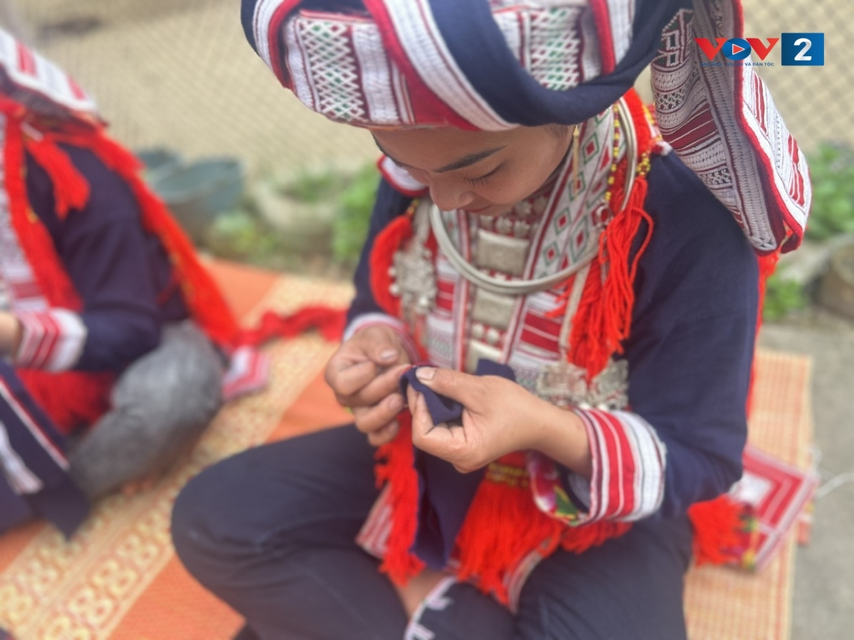 Đôi bàn tay khéo léo của những chị em phụ nữ Dao Đỏ, dệt nên những đường kim mũi chỉ đều đặn và chắc chắn.