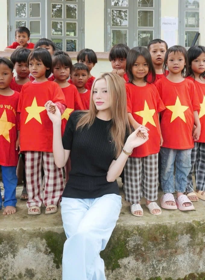 Kỳ Duyên thấy tự hào khi các em bé vùng cao mặc áo cờ đỏ sao vàng để chào mừng cô đến làm từ thiện ở Mường Tè - Điện Biên.
